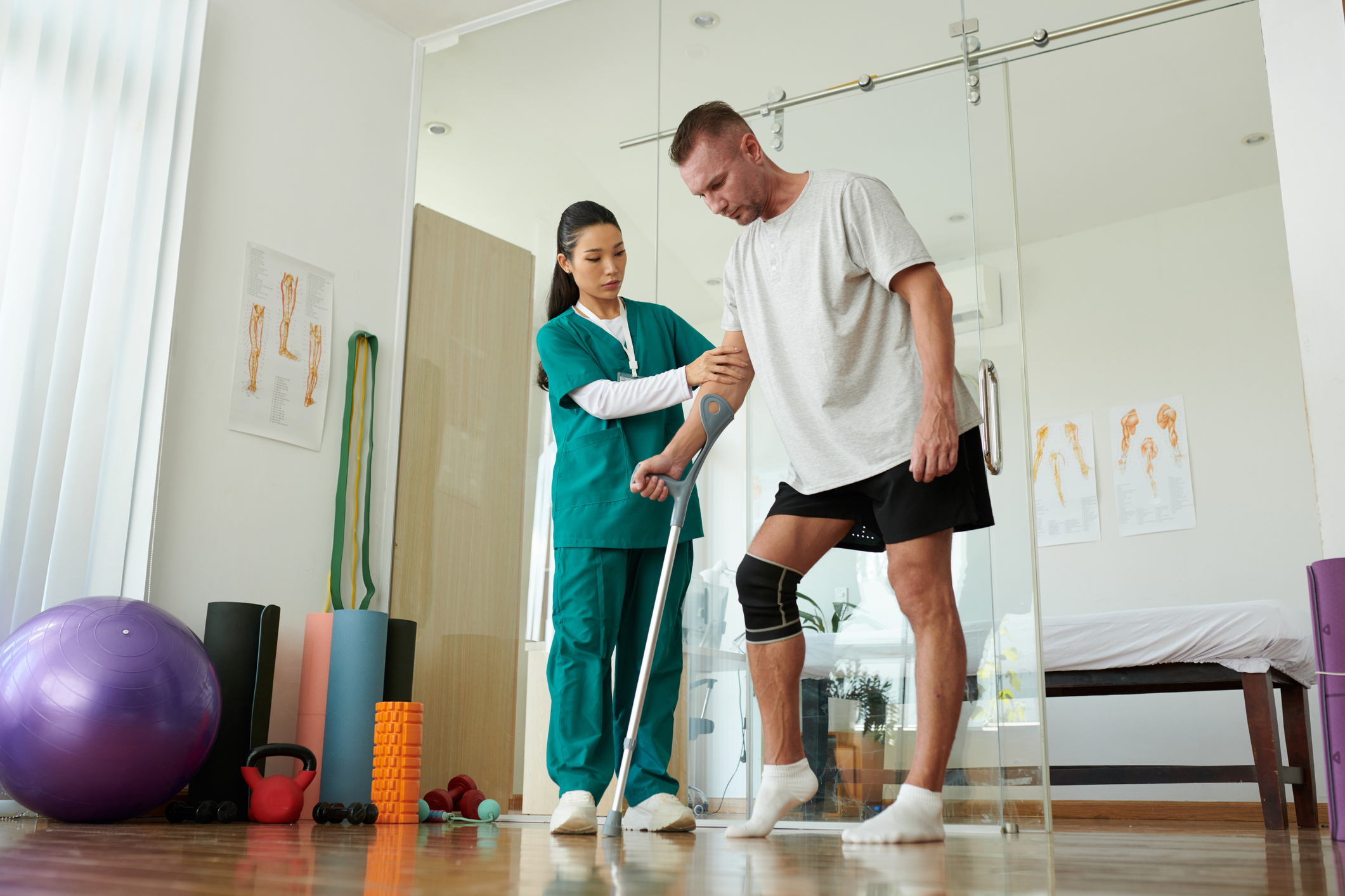 Physiotherapist helping patient with leg injury